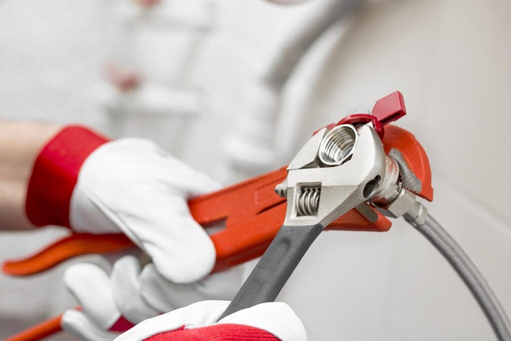 Plumber holding pipe wrenches for an emergency repair in Wesley Chapel