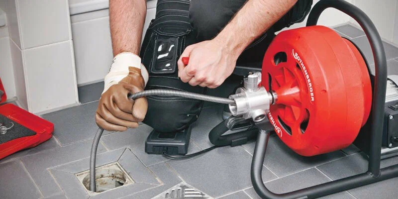 Plumber using a drain-cleaning machine in Wesley Chapel