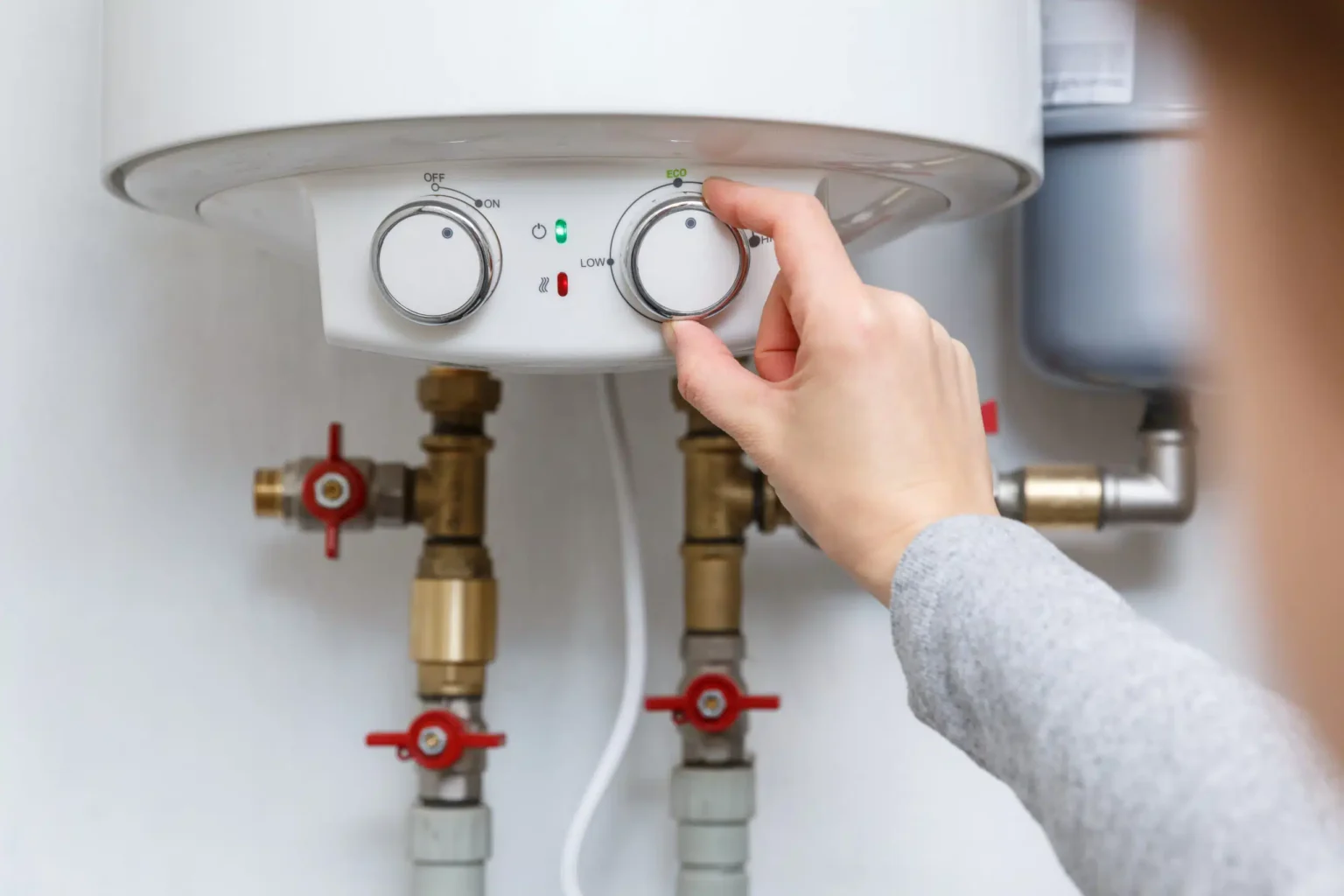 Homeowner adjusting the temperature controls on a water heater in Wesley Chapel
